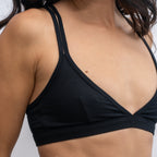 A black Alma bralette, worn by a woman on a neutral background.