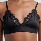 A front shot of a woman wearing a black Alma bralette with lace detailing.